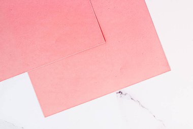 Beyaz mermer arka plan üzerine Pembe A4 kağıtları ofis kırtasiyesi düz döşeme, lüks markalaşma yatağı ve model kimlik tasarımı