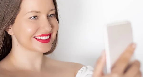 Happy smiling woman with smartphone having video call or taking selfie, portrait on white background. People, technology and communication concept — Stock Photo, Image