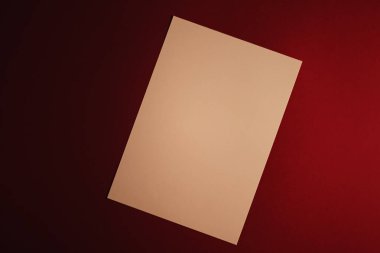 Boş A4 kâğıdı, koyu kırmızı arka planda bej ofis kırtasiyesi, lüks markalaşma düz yatak ve model kimlik tasarımı