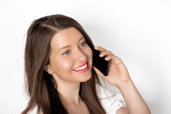Mujer bronceada feliz sonriendo y llamando en el teléfono inteligente de vacaciones, retrato sobre fondo blanco. Concepto de personas, tecnología y comunicación —  Fotos de Stock