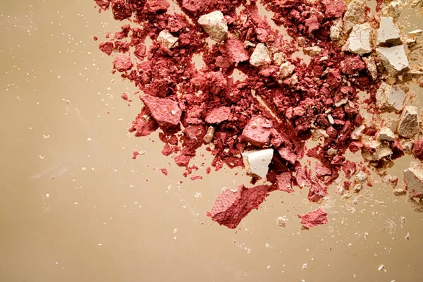 Crushed cosmetics, mineral organic eyeshadow, blush and cosmetic powder isolated on golden background, makeup and beauty banner, flatlay design