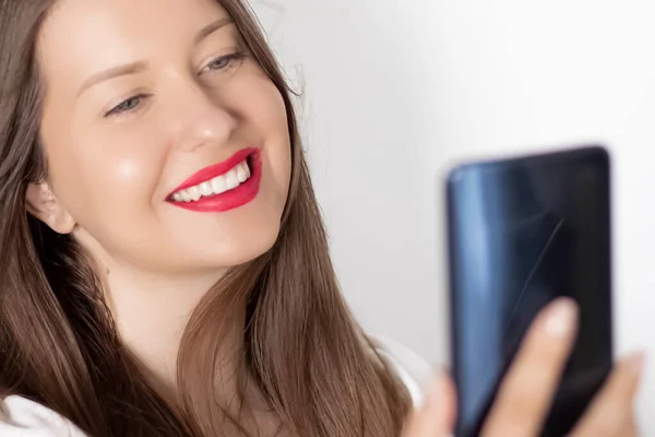 Happy smiling woman with smartphone having video call or taking selfie, portrait on white background. People, technology and communication concept — Stock Photo, Image