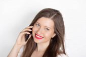 Šťastná usměvavá žena volá na smartphone, portrét na bílém pozadí. Koncepce lidí, technologie a komunikace