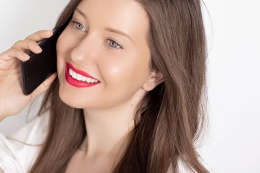 Mutlu gülümseyen kadın akıllı telefondan arıyor, beyaz arkaplanda portre var. İnsanlar, teknoloji ve iletişim konsepti