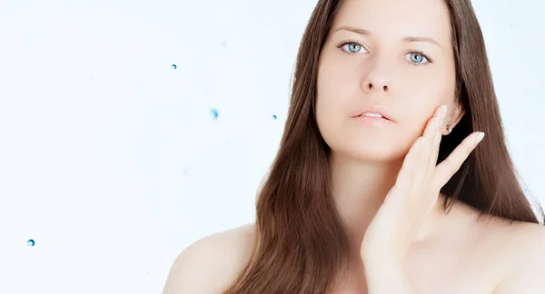 Verjüngung Hautpflege und Schönheitsanzeige, Schönheitsgesichtsporträt einer jungen Frau mit gesunder, sauberer Haut, blaue kosmetische Flüssigkeitstropfen auf dem Hintergrund — Stockfoto
