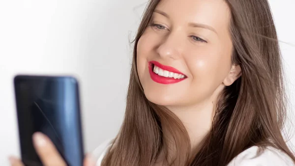 Happy smiling woman with smartphone having video call or taking selfie, portrait on white background. People, technology and communication concept — Stock Photo, Image