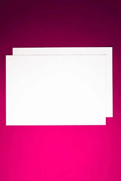 Papier A4 vierge, blanc sur fond rose comme papeterie de bureau flatlay, luxe branding flat lay et design d'identité de marque pour la maquette — Photo