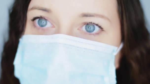 Frau mit leuchtend blauen Augen in Schutzmaske, während Quarantäne-Sperrung durch Coronavirus-Pandemie, Virusinfektionsprävention und Gesundheitsschutzkonzept sicher und gesund zu Hause bleiben — Stockvideo