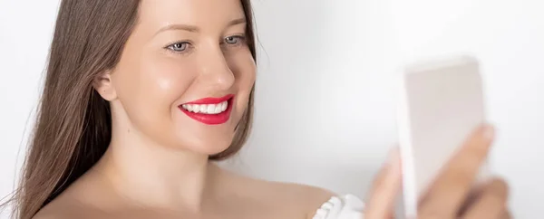 Happy smiling woman with smartphone having video call or taking selfie, portrait on white background. People, technology and communication concept — Stock Photo, Image