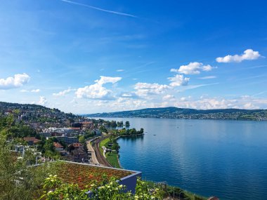 Idyllic İsviçre manzarası, Richterswil, İsviçre 'deki Zürih Gölü manzarası, dağlar, Zürih' in mavi suyu, yaz doğası ve seyahat merkezi olarak gökyüzü, manzaralı sanat baskısı için ideal.