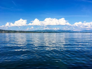 Idyllic İsviçre manzarası, Richterswil, İsviçre 'deki Zürih Gölü manzarası, dağlar, Zürih' in mavi suyu, yaz doğası ve seyahat merkezi olarak gökyüzü, manzaralı sanat baskısı için ideal.
