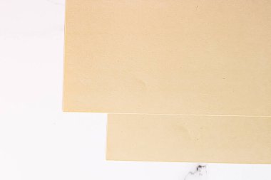 Beyaz mermer arka plan üzerine bej renkli A4 kağıtları ofis kırtasiyesi düz yatak, lüks markalaşma yatağı ve model kimlik tasarımı