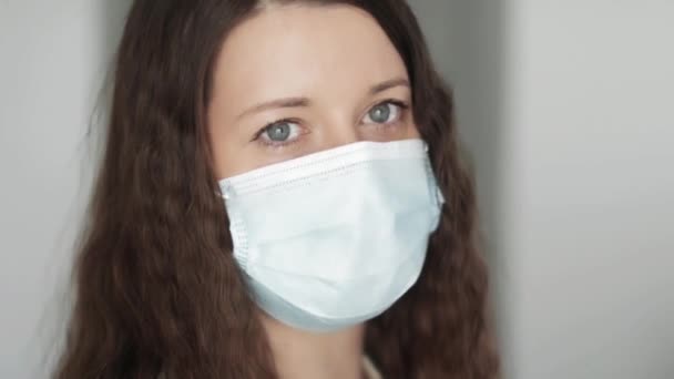 얼굴을 보호하는 마스크를 쓴 여성, 코로나 바이러스 대유행, 바이러스 감염 예방 및 의료 보호 개념으로 인해 검역중 안전하고 건강 한 상태로 집에 머물러 있는 여성. — 비디오