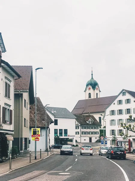 Historic buildings, church and houses on street of Wollerau, canton of Schwyz in Switzerland, Swiss architecture and real estate — Stock Photo, Image