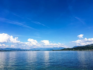 Idyllic İsviçre manzarası, Richterswil, İsviçre 'deki Zürih Gölü manzarası, dağlar, Zürih' in mavi suyu, yaz doğası ve seyahat merkezi olarak gökyüzü, manzaralı sanat baskısı için ideal.