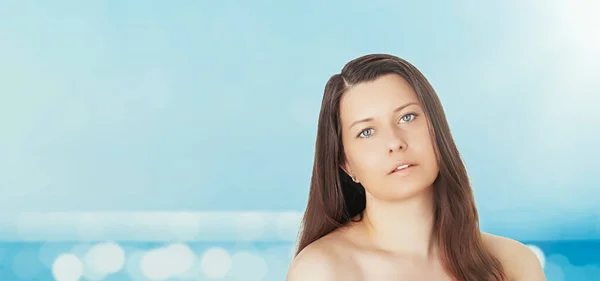 Protezione della pelle e del sole in estate. Ritratto di una bella giovane donna abbronzata, mare azzurro e cielo sullo sfondo, bellezza, benessere e concetto di viaggio — Foto Stock