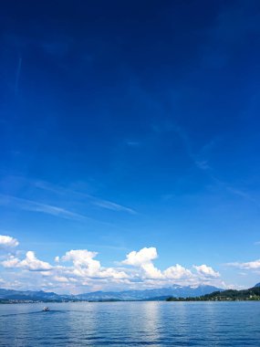 Idyllic İsviçre manzarası, Richterswil, İsviçre 'deki Zürih Gölü manzarası, dağlar, Zürih' in mavi suyu, yaz doğası ve seyahat merkezi olarak gökyüzü, manzaralı sanat baskısı için ideal.