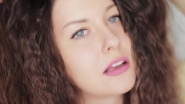 Uzun, sağlıklı kıvırcık saçlı, esmer, dalgalı, kıvırcık saçlı mükemmel beyaz dişli gülüşlü, güzel yüzlü ve doğal organik saç bakım reklamı olan güzel bir kadın.