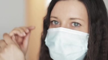 Korunaklı yüz maskeli bir kadın el yıkama deterjanı, el kremi ya da antiviral, koronavirüs salgınında hijyen olarak antibakteriyel jel, virüs enfeksiyonu önleme ve sağlık koruma ile ellerini yıkıyor.