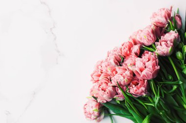 Bayram hediyesi olarak mermer arka planda bahar çiçekleri, tebrik kartı ve çiçek desenleri