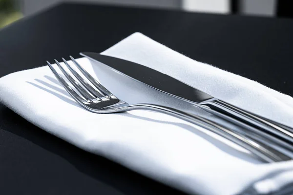 Tenedor y cuchillo con servilleta blanca en la mesa en un restaurante de lujo al aire libre, menú de alta cocina para bodas o eventos y concepto de servicio de catering de alimentos — Foto de Stock
