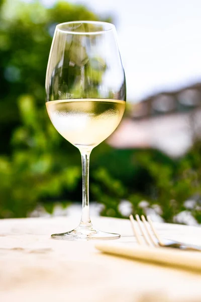 Weißwein im Luxusrestaurant auf Sommergartenterrasse, Weinverkostung im Weingut im Weinberg, Gourmettour und Urlaubsreise — Stockfoto