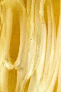 Soyut altın sıvı zemin, boya sıçraması, girdap deseni ve su damlaları, güzellik jeli ve kozmetik doku, modern sihir sanatı ve lüks düz dizayn olarak bilim