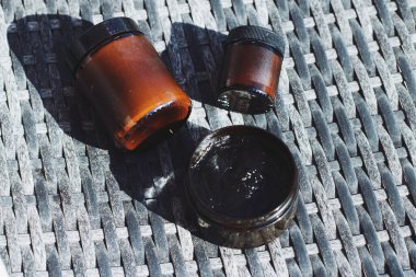 Organik kozmetik ürünleri, kavanozda siyah yüz maskesi, sağlıklı cilt ve vücut bakımı için doğal yeşil çizgi cilt bakımı