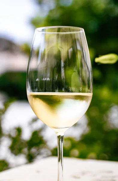 Weißwein im Luxusrestaurant auf Sommergartenterrasse, Weinverkostung im Weingut im Weinberg, Gourmettour und Urlaubsreise — Stockfoto