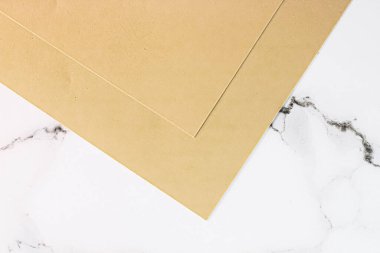 Beyaz mermer arka plan üzerine bej renkli A4 kağıtları ofis kırtasiyesi düz yatak, lüks markalaşma yatağı ve model kimlik tasarımı