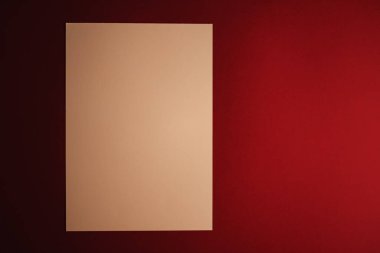 Boş A4 kâğıdı, koyu kırmızı arka planda bej ofis kırtasiyesi, lüks markalaşma düz yatak ve model kimlik tasarımı