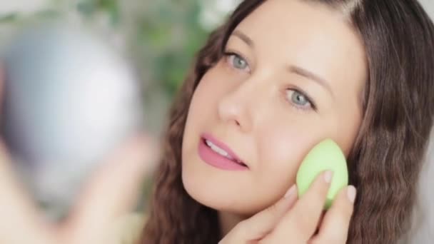 Beautiful woman applying natural organic makeup using beauty blender and smiling, eco make-up sponge tool, face portrait of caucasian model or vlogger as cosmetic product, skincare and people concept — Stock Video