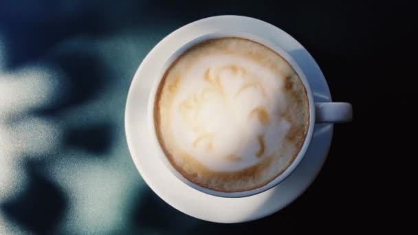阳光灿烂的日子里，一杯卡布奇诺咖啡和早餐在户外桌上 — 图库视频影像