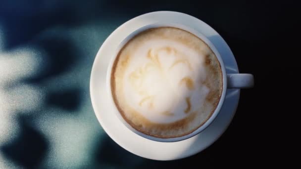 Kopje cappuccino op tafel buiten op zonnige dag, koffie en ontbijt — Stockvideo