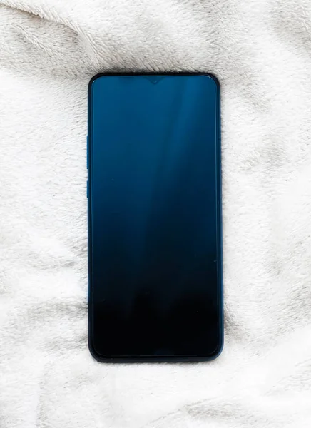Nuevo modelo de teléfono móvil sobre fondo blanco esponjoso, maqueta de planchado de teléfonos inteligentes como plantilla de aplicación y diseño de marketing de marca — Foto de Stock