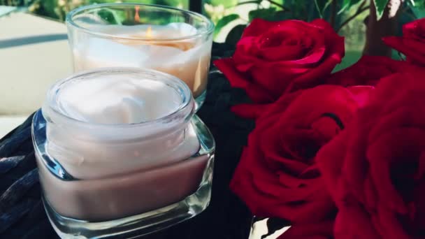 Crema facial, ramo de rosas y vela perfumada en el spa de belleza — Vídeos de Stock