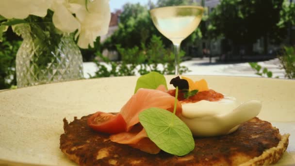 Posiłek na talerzu i kieliszek białego wina na świeżym powietrzu w lecie — Wideo stockowe