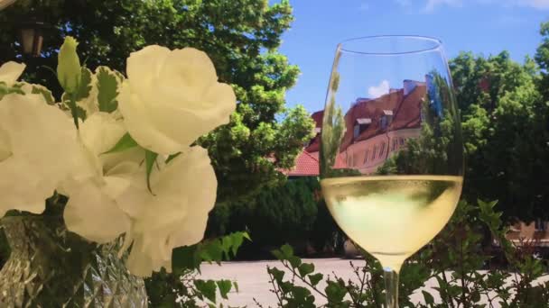 Ποτήρι λευκό κρασί σε ένα εστιατόριο σε εξωτερικούς χώρους, ωραία τραπεζαρία — Αρχείο Βίντεο