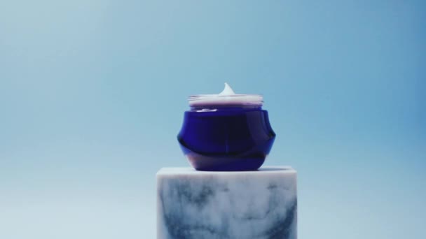 Cura della pelle e cosmetici anti-invecchiamento, crema viso di bellezza in vaso su sfondo blu — Video Stock