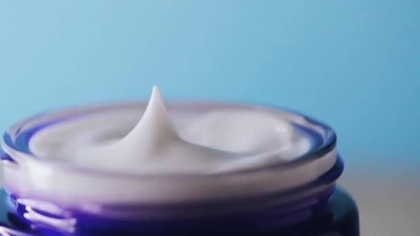 Anti-aging huidverzorging en cosmetica, schoonheid gezichtscrème in pot op blauwe achtergrond — Stockvideo
