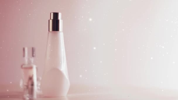 Perfume de lujo ambientado sobre fondo rosa, nieve y brillo navideño — Vídeos de Stock