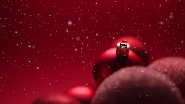 Kırmızı dekoratif Noel süsleri, bayram tatili arka planı, yağan kar ve parıltı gibi. — Stok video