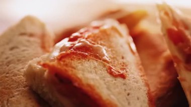 Sandviç tost makinesinde pişirilmiş sıcak üçgen peynirli sandviçler, ev yapımı konforlu yemekler.