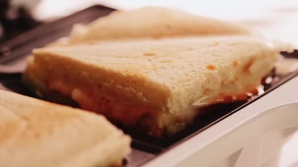 Sandwiches de queso triangular calientes cocinados en tostadora sándwich, comida casera confort — Vídeo de stock