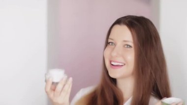 Doğal cilt bakım ürünleri, yüz kremi nemlendirici, kozmetik losyon veya emülsiyon maskesini lüks cilt bakımı rutini ve güzellik kozmetik reklamı olarak kullanarak parlayan sağlıklı cilde sahip güzel bir kadın.