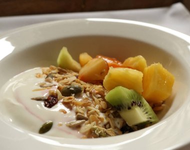 Yogurt with granola, kiwi, pineapple, and seeds for a healthy breakfast. Cotswolds countryside, England