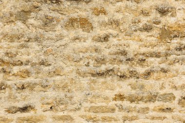 Kırsal dokuya sahip yıpranmış taş duvar, görünür havan topu ve doğal liken büyümesi, eski bir arkaplan oluşturur. Cotswolds, İngiltere