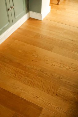 Kapalı bir yaşam alanındaki ahşap döşeme tahtaları ve süpürgelikler, doğal ahşap tahıl ve yerli yenileme çalışmaları içeriyor.