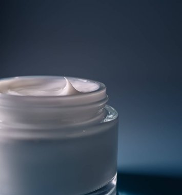 Saf cam bir kavanozda kremalı beyaz kozmetik ürünü dokusu doruk noktasında, güzelliği, cilt bakımını ve tazeliği ön plana çıkarıyor.