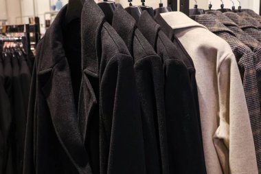 Moda perakende satış ve tüketim için giysiler sergilenen askılarda çeşitli kışlık paltolar